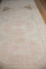 Softly worn pile of a distressed Oushak runner showing even wear and faded pink tones.