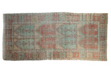 Distressed vintage Oushak runner with geometric panels in alternating soft green and burnt orange red.