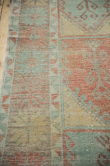 Close-up showing the evenly worn pile and soft colors of a distressed Oushak runner.