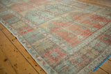 Angled view showing the even wear and faded geometric patterns of a vintage Oushak rug.