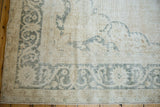 Distressed Turkish Sparta rug corner, ivory field with moss charcoal serrated floral border detail.