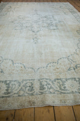 Distressed ivory and moss charcoal border of the vintage Sparta carpet, showing worn pile.