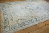 Distressed vintage Sparta carpet border, worn ivory and moss charcoal arabesque.