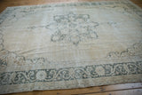 Distressed vintage Sparta carpet corner, wear to knot heads, dusty moss serrated floral border.