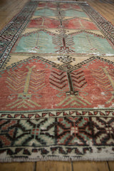 A low-angle perspective on the distressed texture and repeating tree of life design of a vintage runner.