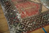 Intact side cord and serrated leaf border on a distressed vintage Oushak runner.