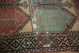 Visible foundation and worn texture on a distressed Turkish Oushak rug in mint and red.