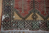Distressed corner of an Oushak runner with a serrated leaf border, saffron accents, and ivory fringe.