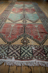 Low-angle perspective down the vintage Oushak runner showing its worn pile and fringe.