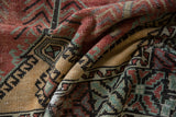 Textured, time-softened pile of a vintage Oushak in rich red, mint green, and saffron gold.