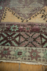 Distressed Oushak runner's hand-knotted pile with saffron, aubergine, mint, and silver panels.