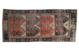 Distressed Oushak rug runner featuring burnt orange, charcoal, and ivory paneled tree of life motifs.