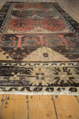 Distressed charcoal and burnt orange pile with ivory fringe on vintage Oushak runner.