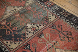 Distressed vintage Oushak runner's paneled design with scrolling motifs in burnt orange, charcoal, and ivory.