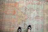 Worn knot heads and distressed low pile on a vintage Oushak runner with mint and orange tones.