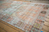 Angled view of the distressed Oushak runner's multi-panel design in mint and orange.