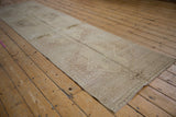 Distressed Oushak runner showcasing muted ivory patterns with foundation showing through.