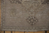 Vintage Oushak runner lower corner, showing distressed beige pile and chevron border.
