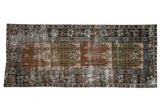 Vintage distressed Oushak rug runner with a multi-panel germinating design in rust, sage green, and ivory tones.