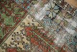 Worn pile showing foundation across geometric panels in sage green, rust, and powder blue.