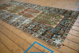 Angled view of a distressed Oushak runner showing its reciprocating geometric panels in sage and rust.