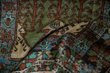 Distressed Oushak rug runner folded to reveal low pile texture and sage green geometric motifs.