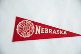 Red felt detail of Vintage Nebraska University pennant with white 'Nebraska' lettering and crest.