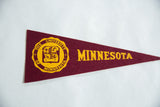 The gold seal and lettering on the maroon felt of a vintage University of Minnesota flag.