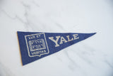 Vintage Yale pennant detail: blue felt with silver 'Lux Et Veritas' shield graphic.