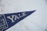 Close-up of blue felt Yale University pennant with YALE text and Lux Et Veritas graphic.