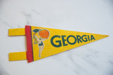 Yellow felt Georgia pennant, bather graphic holding giant peach and green lettering.