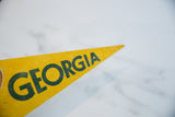 Textured yellow felt Georgia pennant with dark green 'ORGIA' lettering and pointed tip.