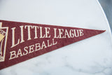 Detail of cream 'Little League Baseball' text on vintage burgundy felt pennant.