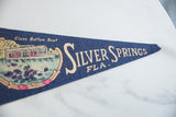 Navy blue felt pennant tip with white 'SILVER SPRINGS FLA.' text, showing slight wear.