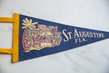 Vintage blue felt St. Augustine pennant, featuring beige graphic, yellow trim, and textured felt.