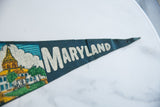 Close-up of vintage Maryland felt pennant, showcasing textured blue felt and cream 