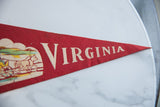 Vintage red felt Virginia pennant, showcasing white 'VIRGINIA' text and horse-drawn carriage graphic.