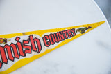 Pointed tip of a vintage yellow felt flag with red 