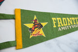 Close-up of vintage Frontier City felt pennant, showing yellow binding and vibrant cowboy graphic.