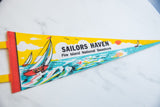 Vintage felt pennant tip featuring retro orange sun, sailboat graphic, and light blue water.