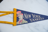 Beige 'New York Yankees' lettering on a textured deep blue vintage felt pennant.