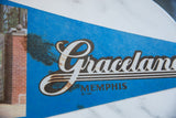 Blue felt Graceland pennant with white script lettering and visible brown marks.