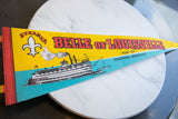 Vintage felt pennant with 'STEAMER' text, fleur-de-lis, and partial steamboat illustration.