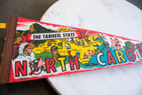Vibrant felt texture on North Carolina pennant, with 'CAROL' and state map graphics.
