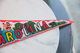 Vintage North Carolina felt flag showing 'AROLINA' letters and Tarheel state bear graphics.
