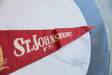Red felt vintage pennant featuring white St. Johnsbury VT text and yellow graphic detail.
