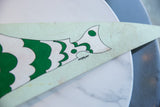 Vintage felt pennant with stylized green, white fish artwork, subtle marks on pale green.