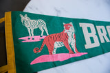 Green felt pennant featuring yellow trim, white zebra, and pink base graphic.
