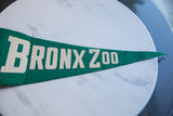 Vintage green felt pennant displaying 'X ZOO' in off-white, with pointed end.