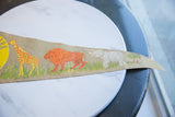 Close-up of vintage Prospect Park felt pennant with retro giraffe, lion, elephant graphics.